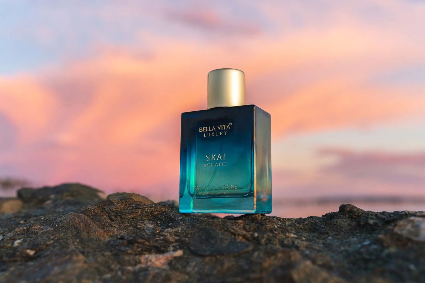 Original photo of the perfume bottle on rocks at sunset